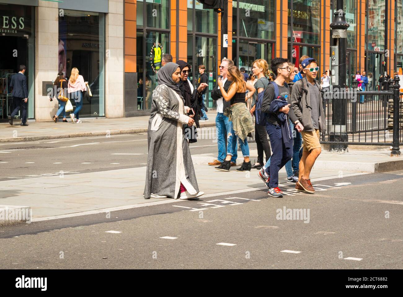 London West End Knightsbridge street scene shoppers pedestrian crossing road young people Arab Muslim girls hijabs abayas shop windows Stock Photo