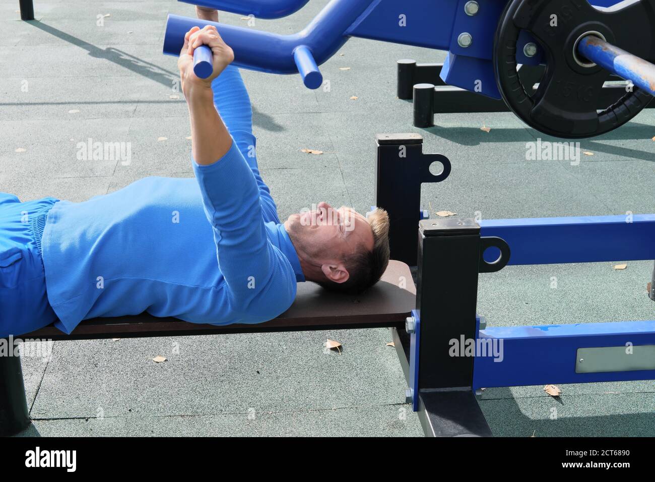sporty slim man doing bench press using outdoors gym equipment. making an  effort to lift a bar. motivation and progress concept. chest exersice Stock  Photo - Alamy