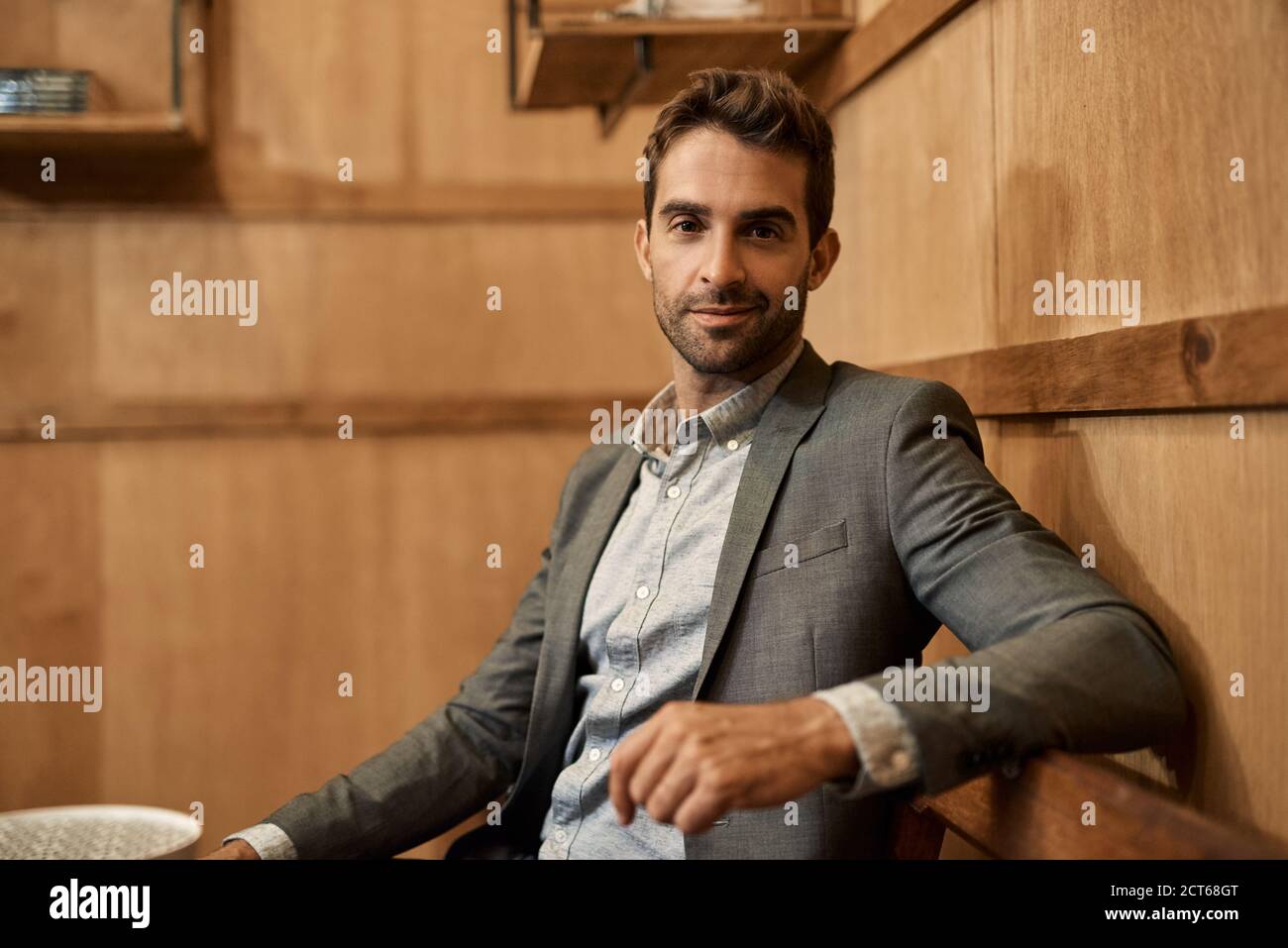 Stylish man in a blazer sitting in a trendy lounge Stock Photo