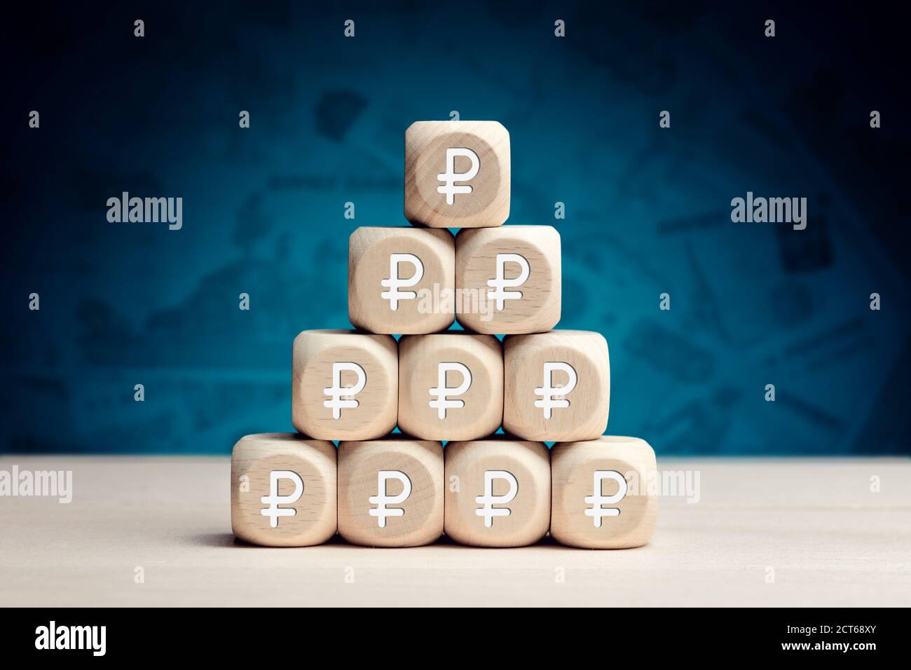 Russian Ruble symbol on wooden cubes against money background. Financial reserves, growth, profit, investment or savings in business concept. Stock Photo