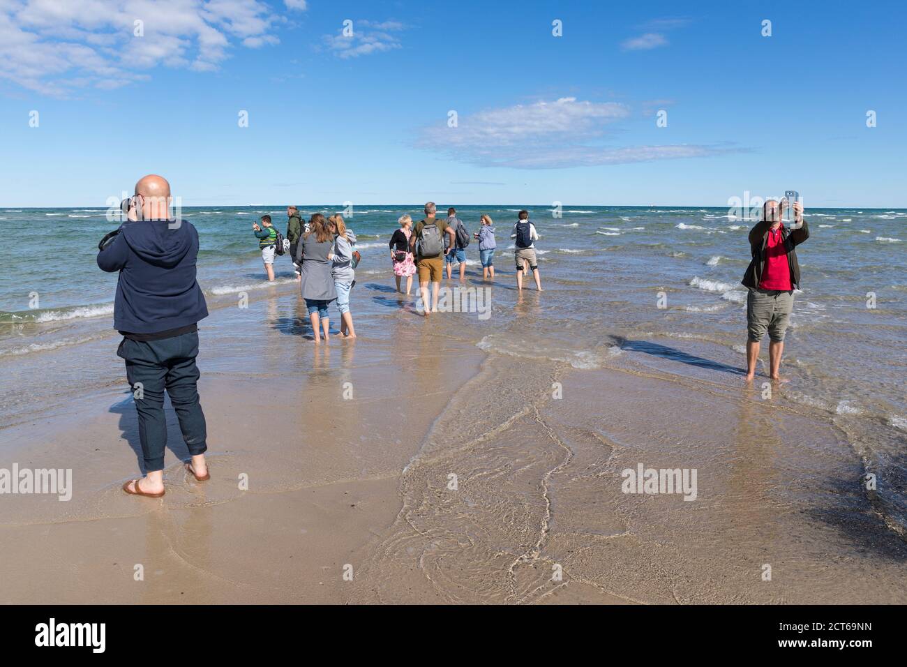 Skagen, Denmark - August 31, 2020: At Grenen, the northernmost point of Denmark, where Baltic Sea and North Sea waves meet, tourists are taking photos Stock Photo