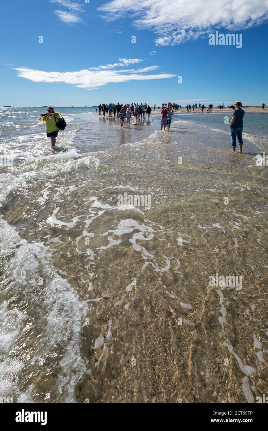 Skagen, Denmark - August 31, 2020: Photo of tourists at Grenen, northernmost point of Denmark, taken standing with one foot in the Baltic Sea and the Stock Photo