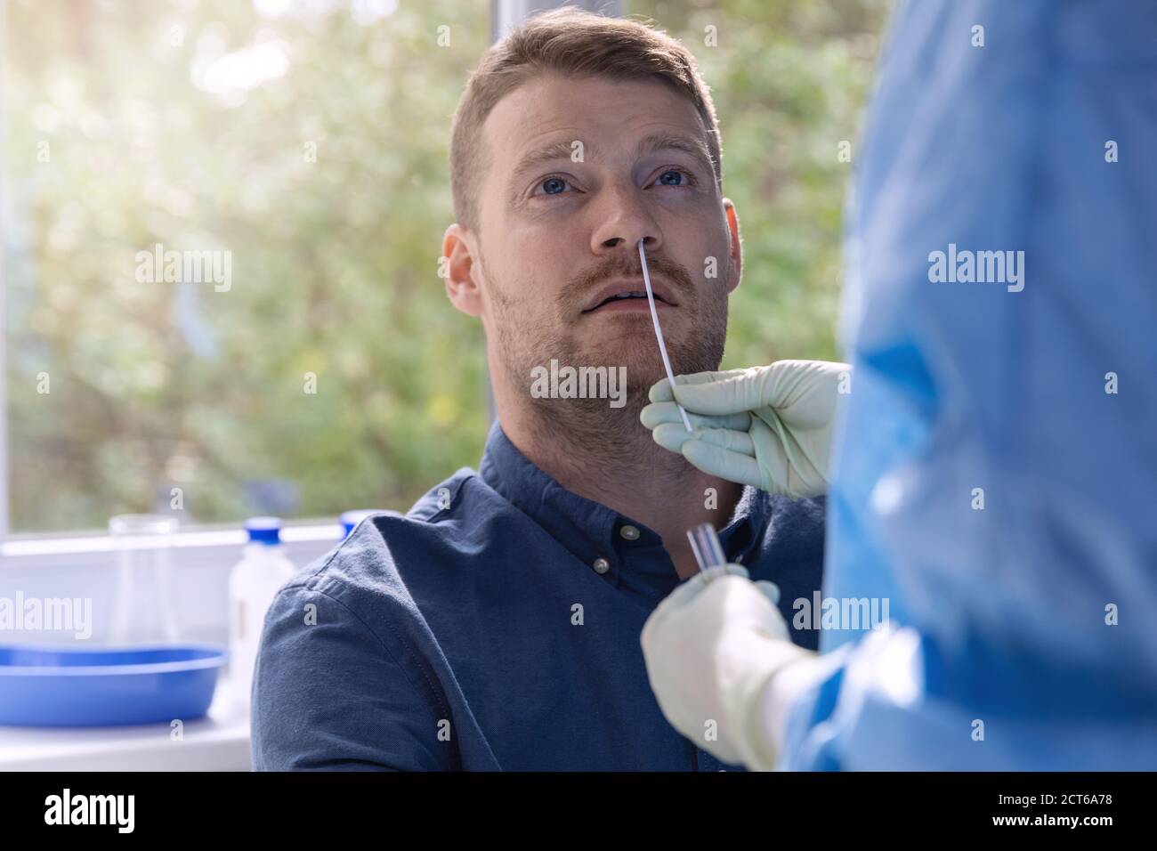 covid-19 nasal swab test - doctor taking a mucus sample from patient nose in hospital Stock Photo