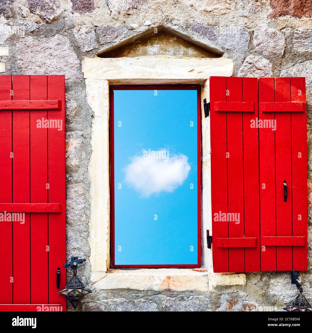 Window on a stone wall with blue sky and cloud view. Imagination, dreaming, freedom or inspiration concept. Stock Photo