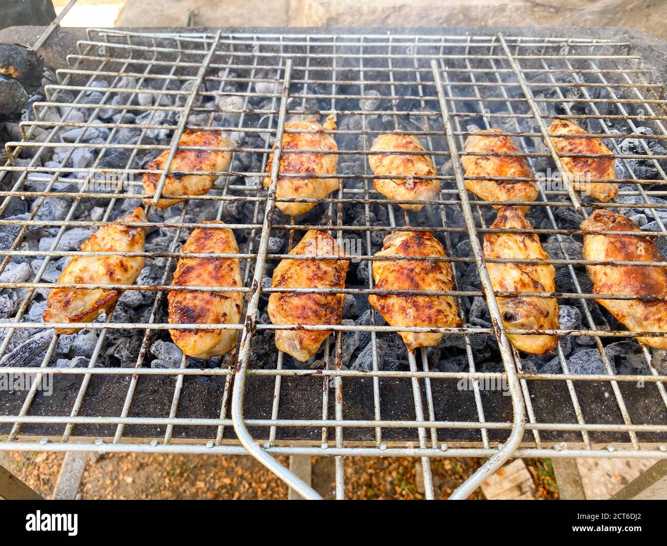 Delicious Grilled chicken on barbecue. Chicken wings on the mangal in nature. Picnic. Close Up. Stock Photo