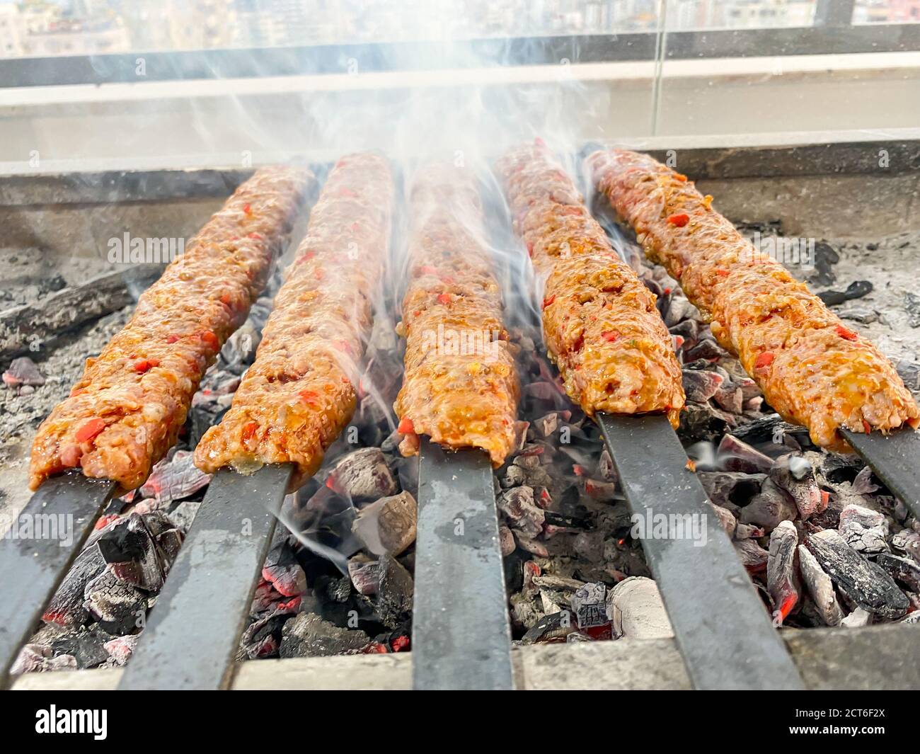 Traditional Turkish Adana  Kebap on the grill with skewers  for dinner. Turkish cuisine food culture in Turkey. Adana kebab on the mangal Stock Photo