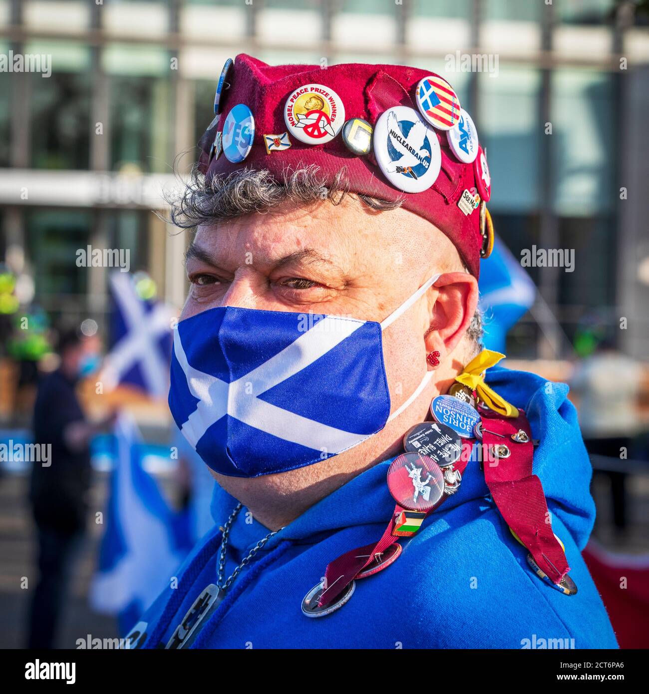 Scottish Independence supporter wearing a saltire face mask a glengarry beret with pro independence badges, Taken at an independence political rally, Stock Photo
