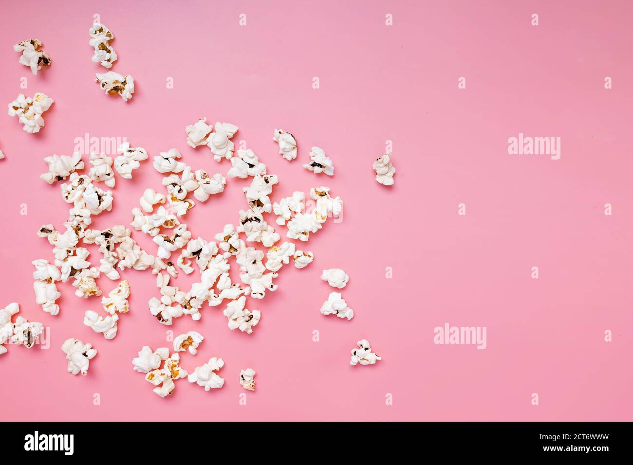 Popcorn scattered on pink background Stock Photo