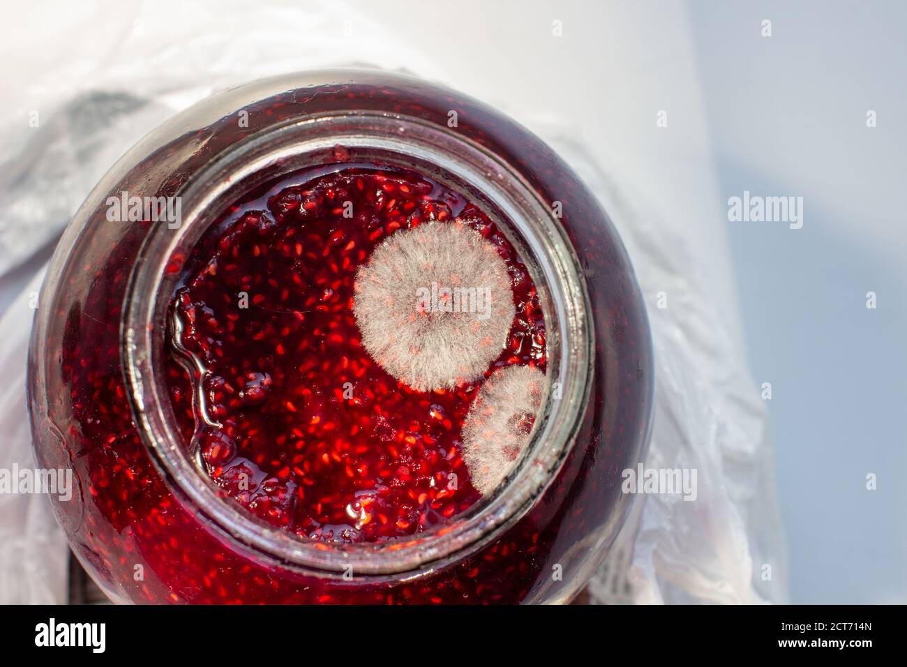 Mold in a jar of raspberry jam. Hazardous to health.  Stock Photo