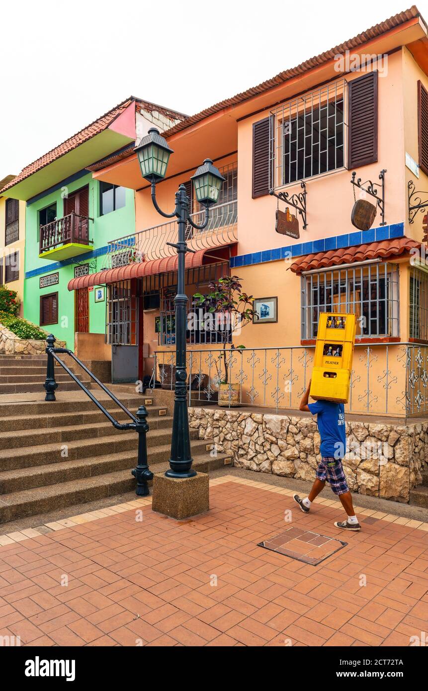 Ecuadorian man carrying beer crates in the colonial district of Las Penas, Santa Ana Hill, Guayaquil, Ecuador. Stock Photo
