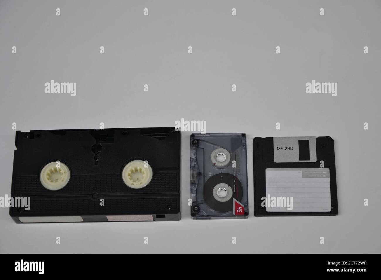 VHS tape, audio tape and floppy disk, used for recording images, music and computer data, three types of vintage technology, on white background, copy Stock Photo