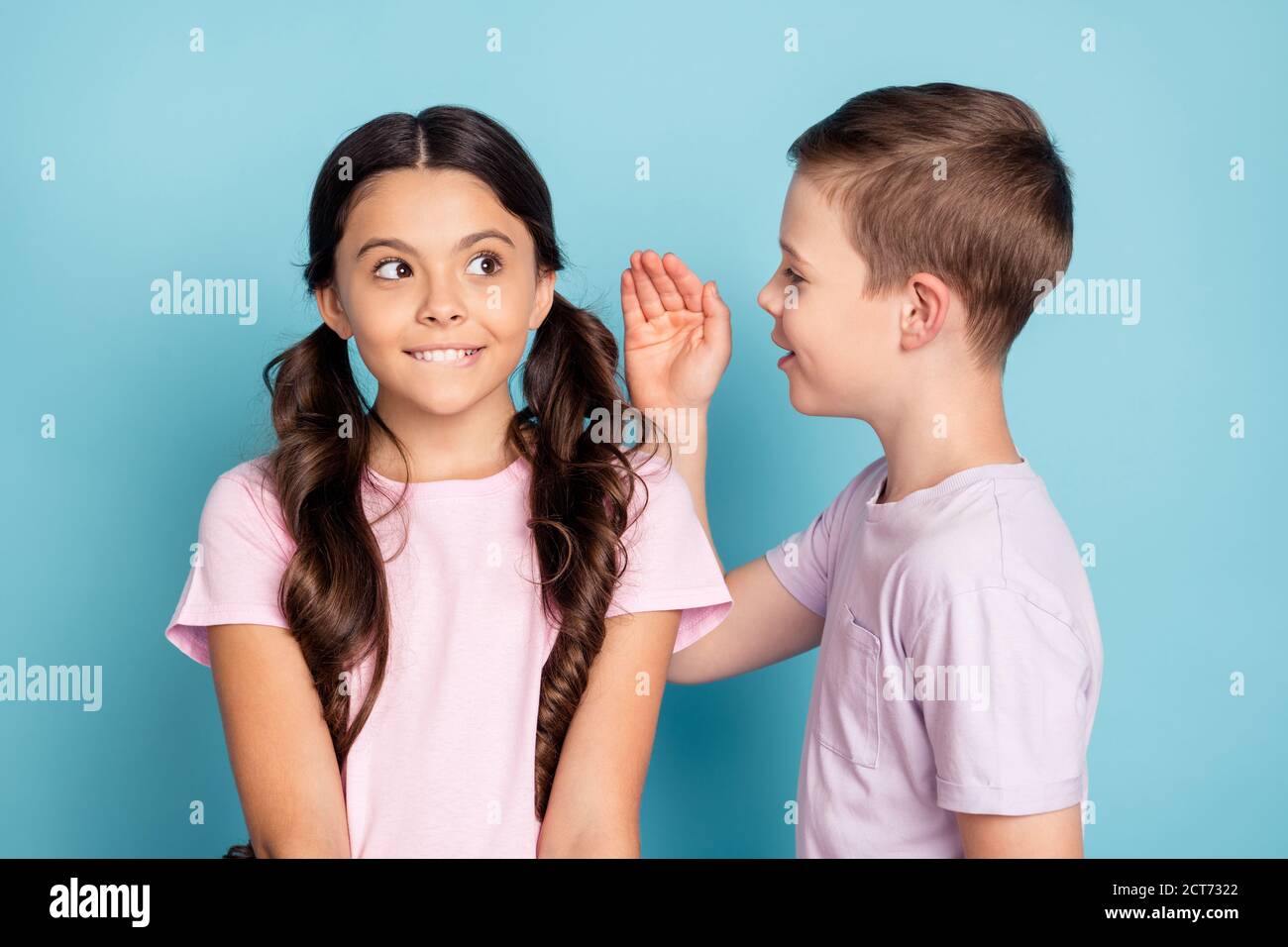 Listen i know where ice cream. Two little people kids boy speak talk private information hand girl bite lips teeth think inspired thoughts wear casual Stock Photo