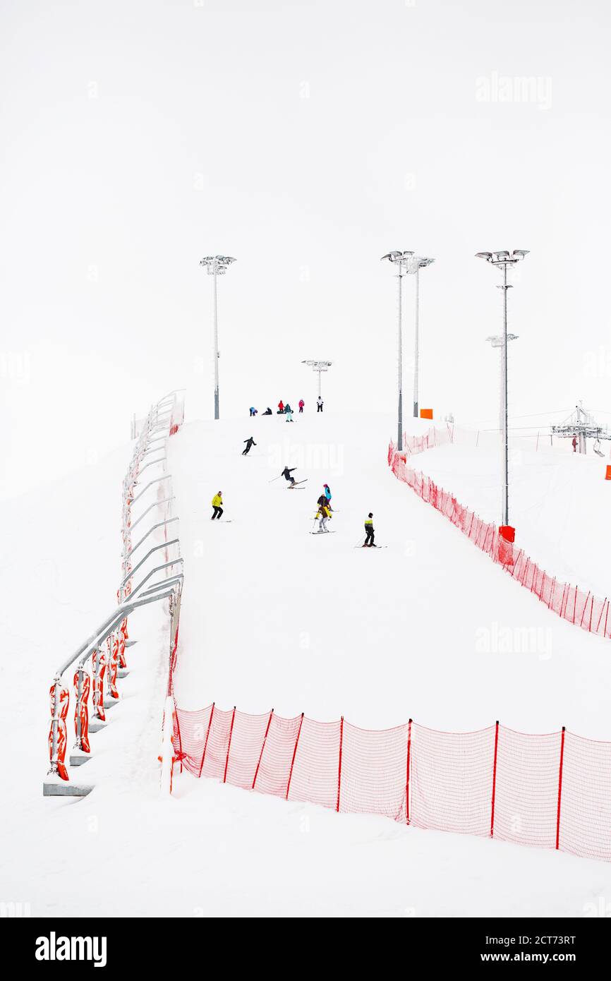 Ski slope with skiers in winter landscape, extreme winter sports Stock Photo