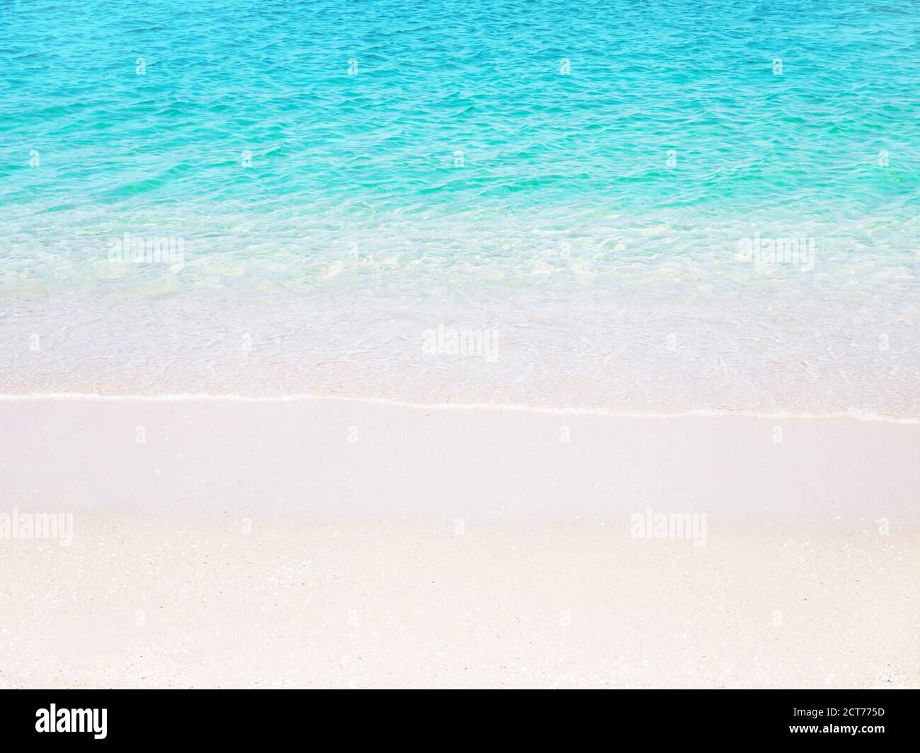 Beach background. Tropical paradise. Sandy shore washing by the wave. Crystal clear turquoise sea water. Dreams summer vacations destination. Stock Photo