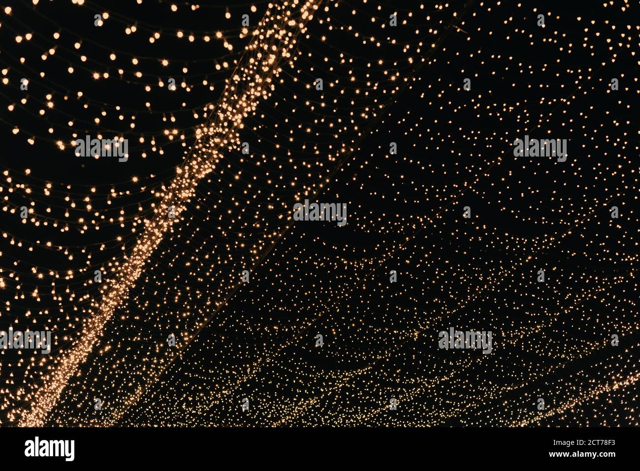 Many lightbulbs hanging on cable as garland decorative in festival isolated on dark night sky background, beautiful design of light string Stock Photo