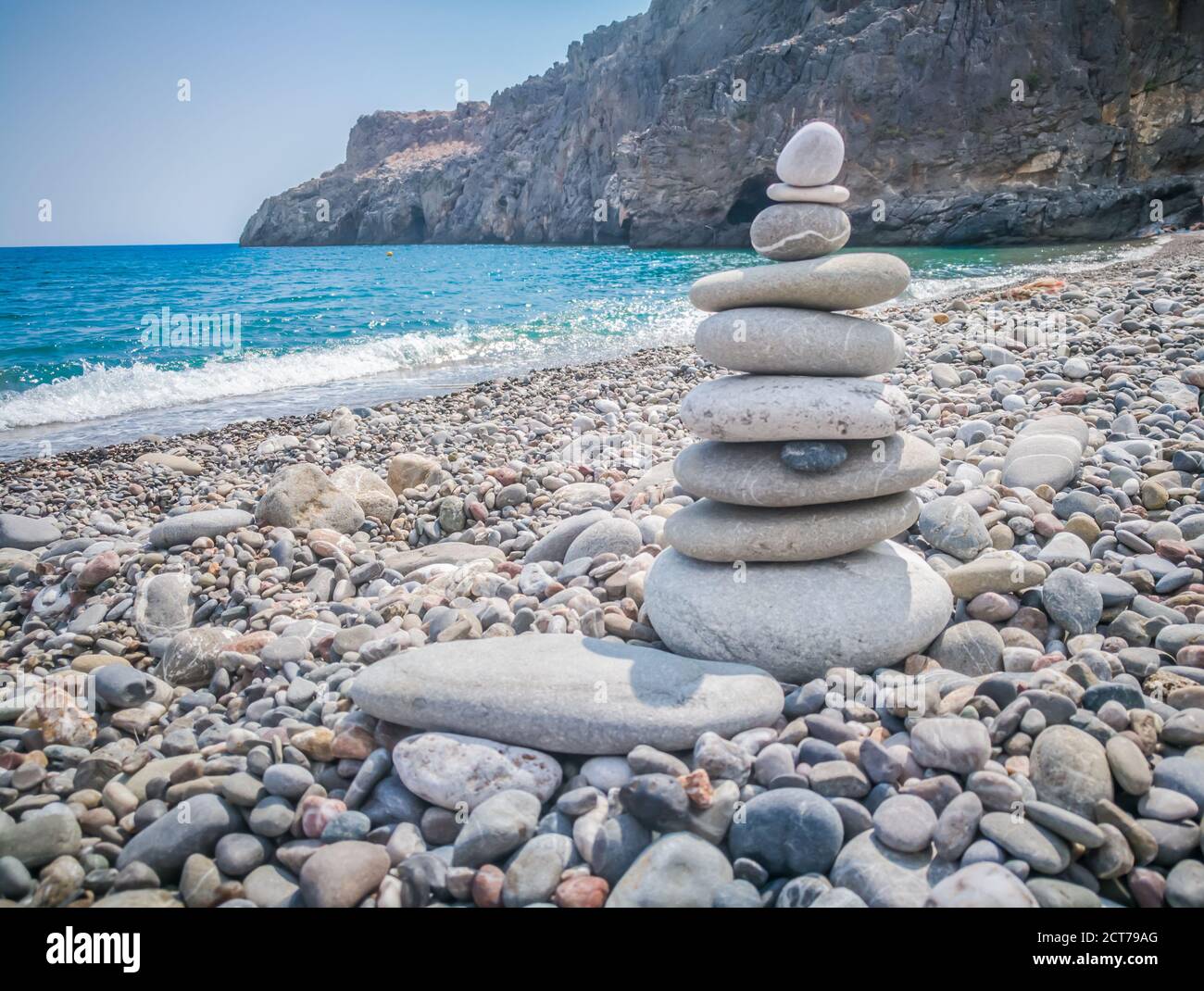Symbolic scales of stones against the background of the sea and blue sky. Concept of harmony and balance. Pros and cons concept. Copy space for text. Stock Photo