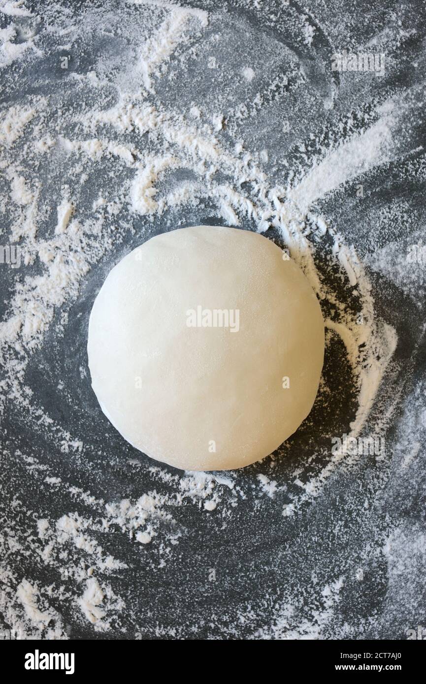 Dough ball on floured gray background. Made for cooking pastries. Food concept.Vertical orientation. Stock Photo