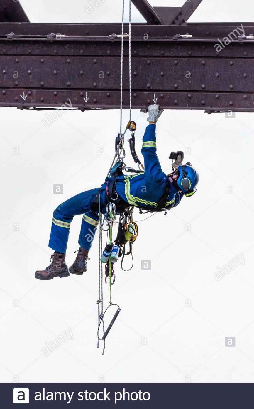 Steeplejack industrial climber using rope access to inspect bridge maintenance repair Toronto Ontario Canada Stock Photo