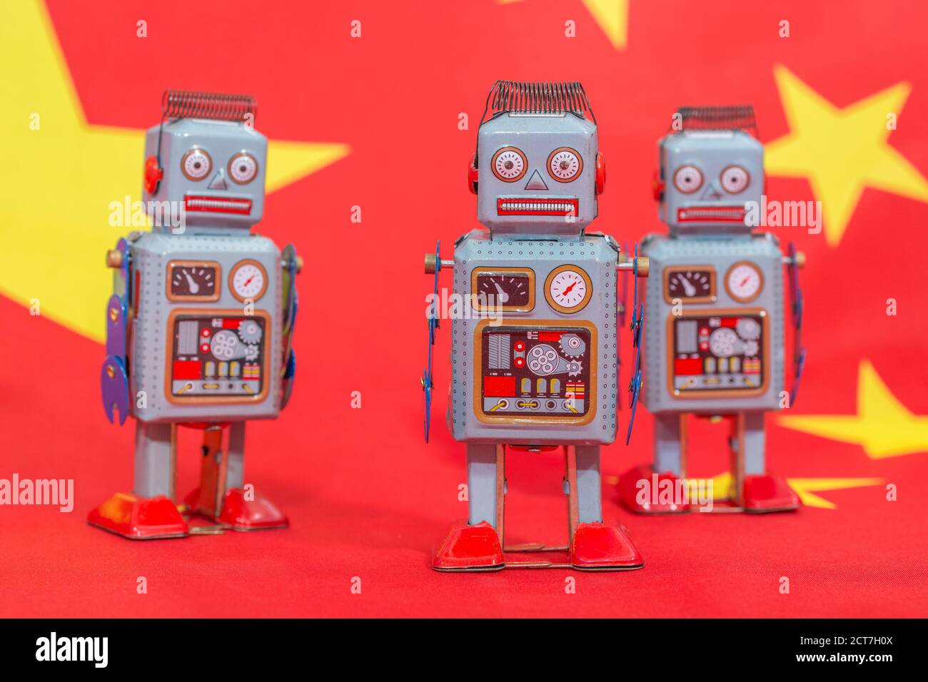 Wind-up clockwork toy robot on Chinese flag b/gd. For Chinese bots influencing US elections, advances in Chinese AI, China troll farm, China AI Stock Photo