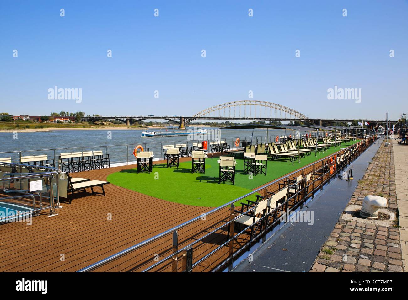 Nijmegen, Netherlands - September 18. 2020: View from river promenade over empty cruise ship on river waal with arch bridge waalbrug background Stock Photo