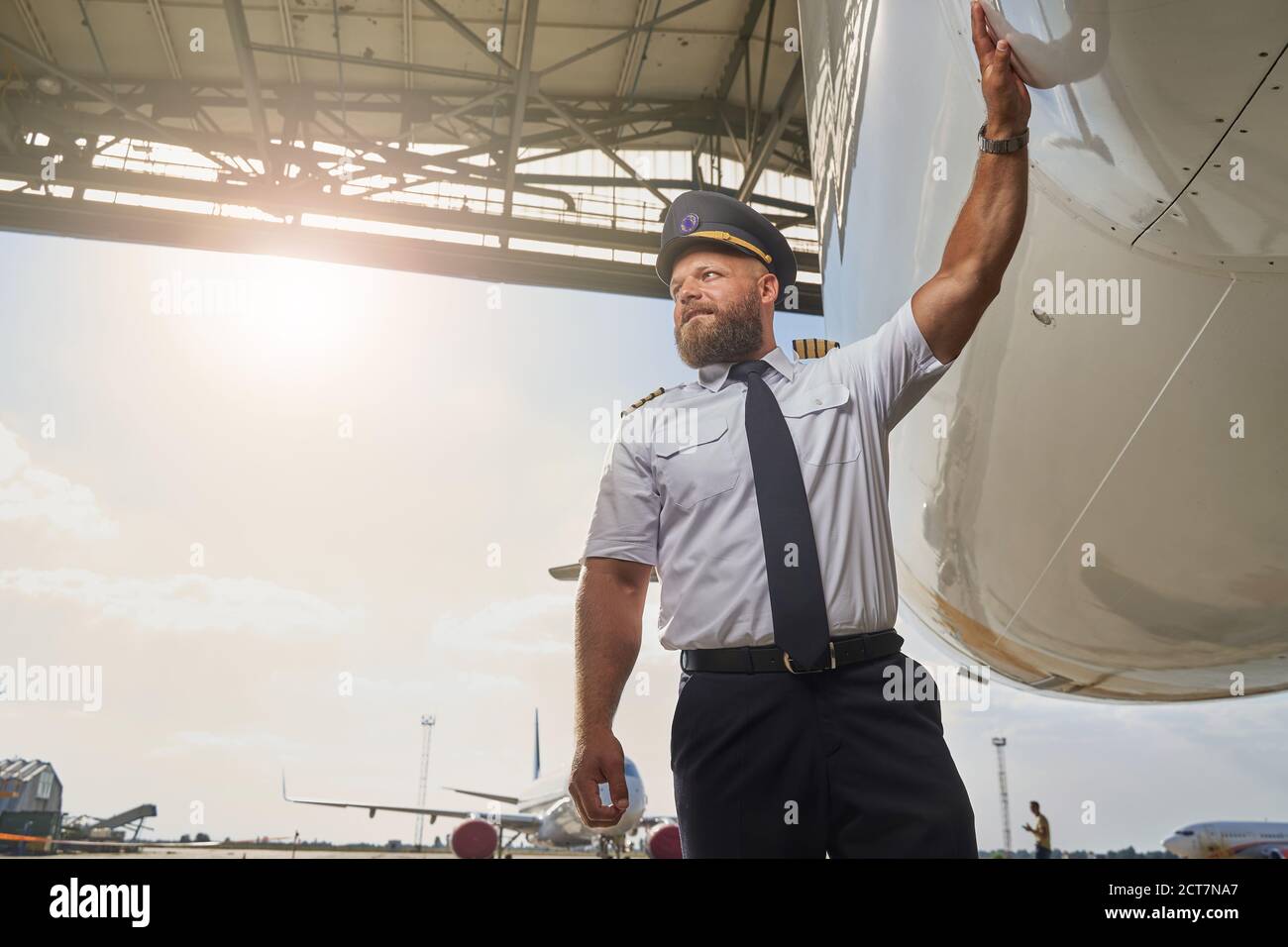 Professional pilot near his plane in the airport Stock Photo