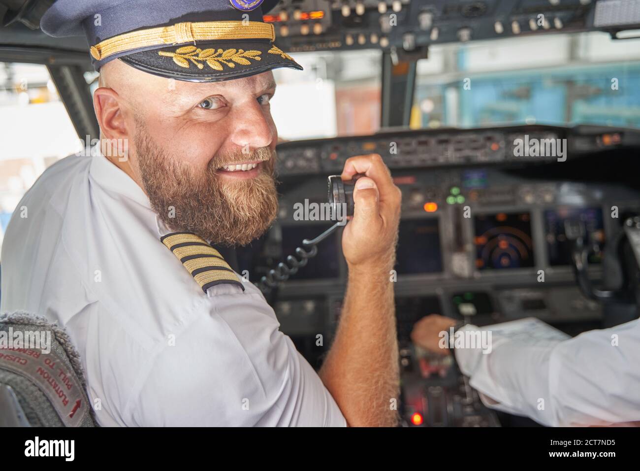 Friendly pilot smiling and announcing the flight start Stock Photo