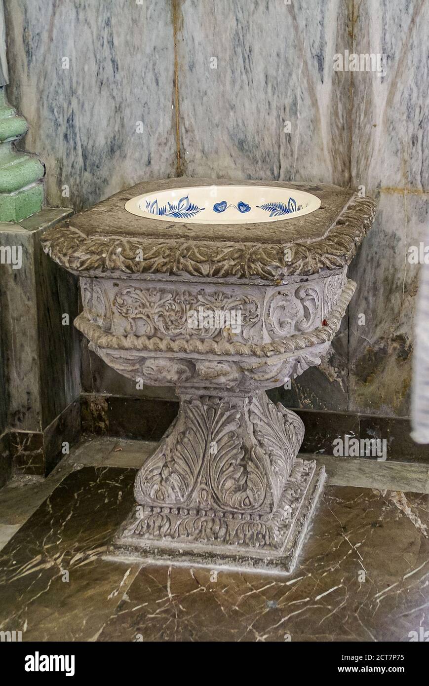 Puerto Vallarta, Mexico - April 25, 2008: Church of Our Lady of Guadalupe. Sculpted stone baptismal font set against marble wall. Stock Photo