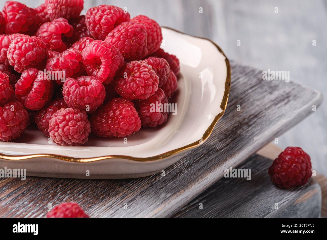 Raspberry fruits in plate on old cutting boards, healthy pile of summer ...