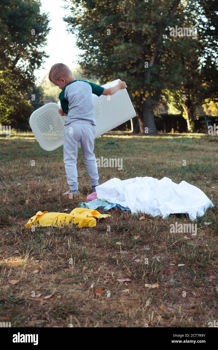 the kid throwing clothes out of the basket. outdoor Stock Photo Alamy