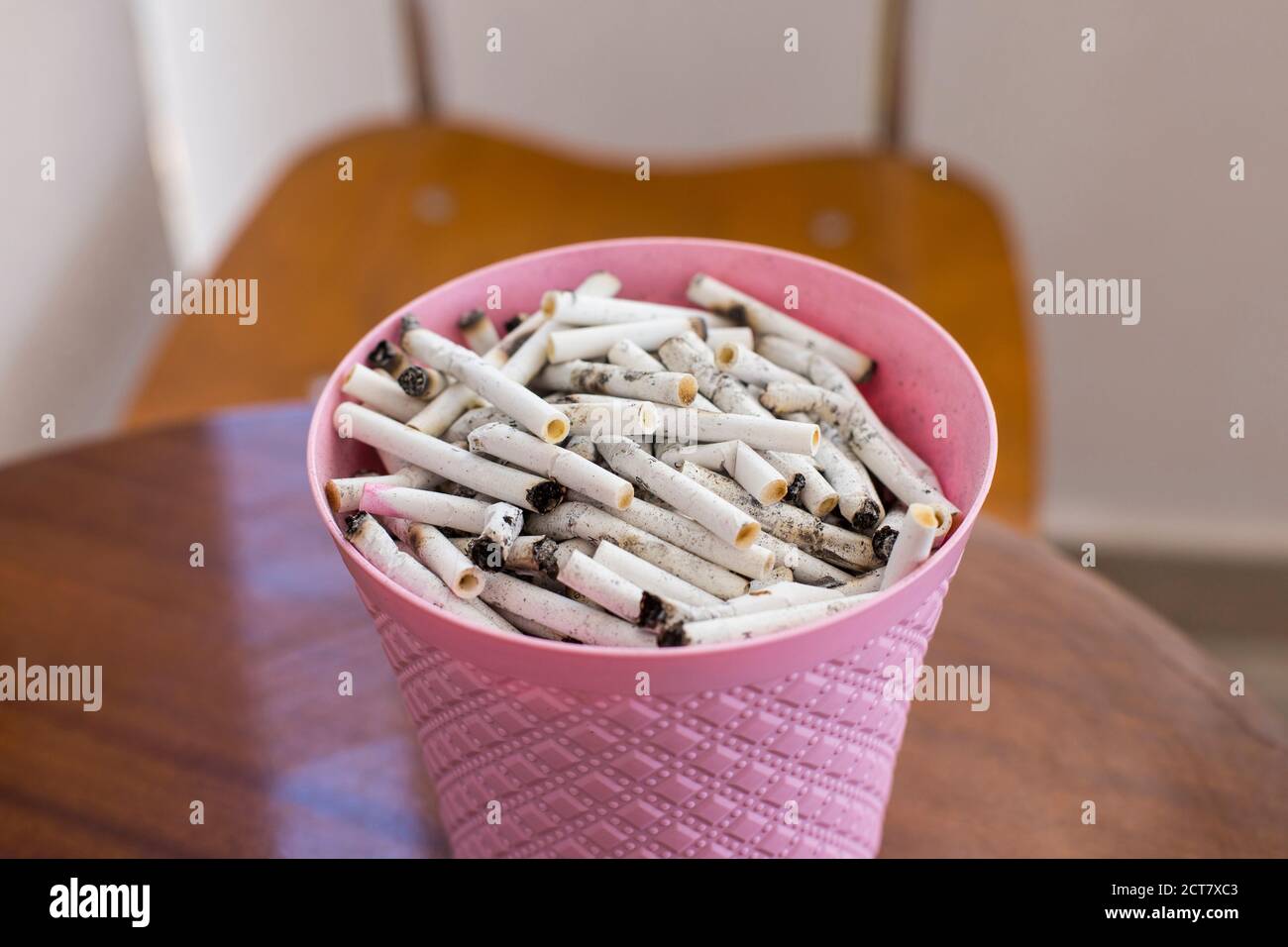 A bucket of cigarette butts on the table Stock Photo - Alamy
