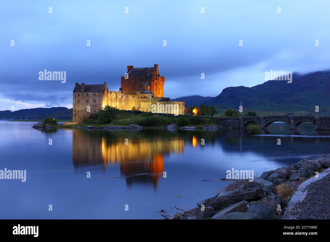 Eileen Donan Castle floodlit after sunset on a cloudy evening, West Highlands, Scotland, UK Stock Photo