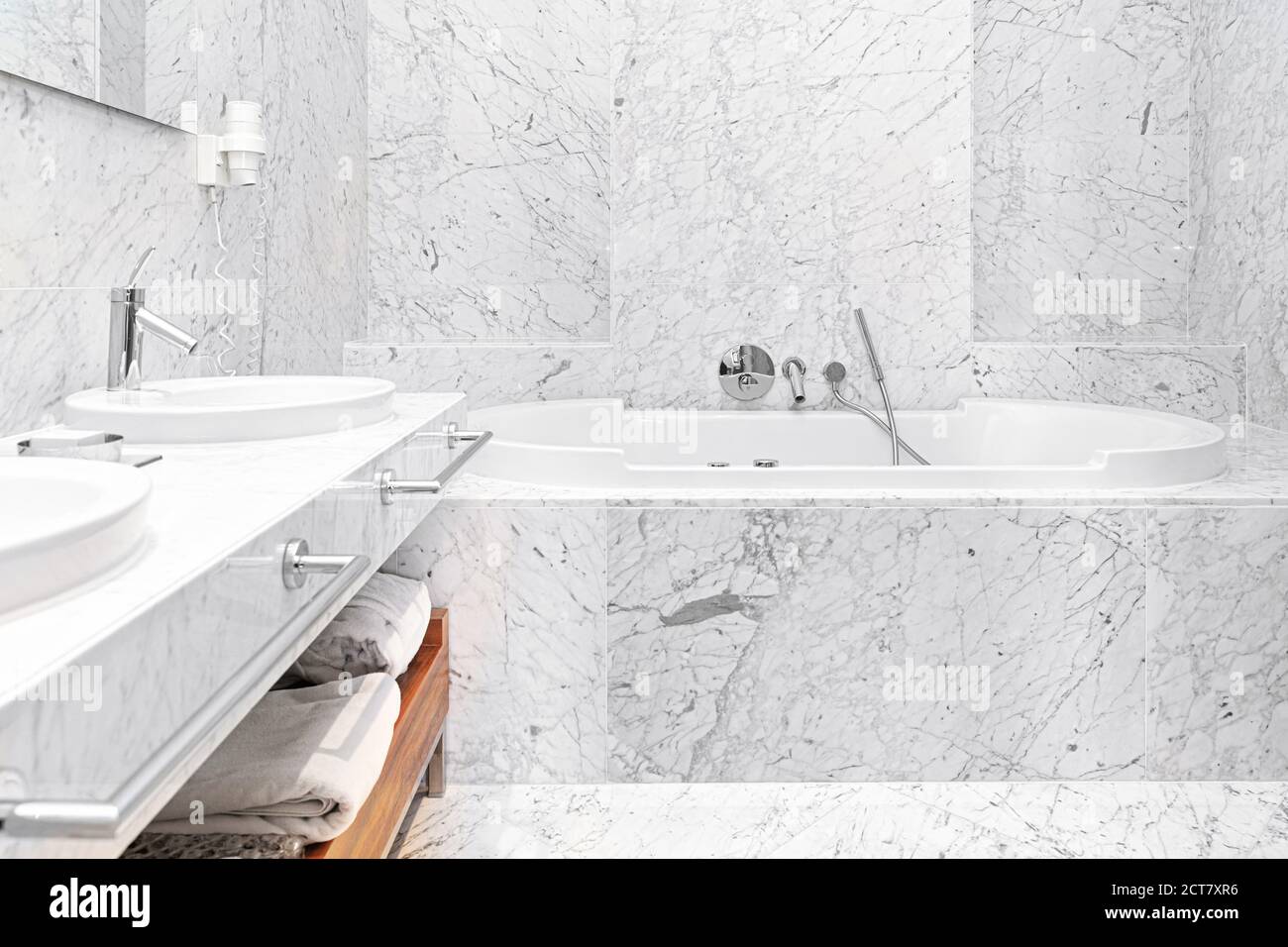 beautiful interior of a modern white marble hotel batroom with bathtube and towels Stock Photo