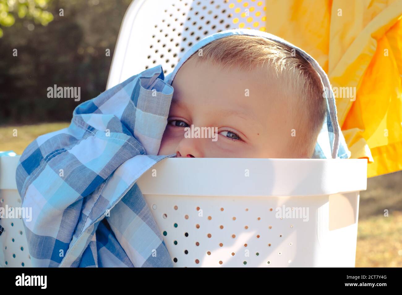 child playing hide and seek.cute boy looking out of the laundry basket Stock Photo