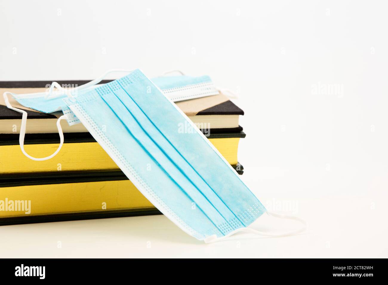 Education and coronavirus precautions in schools seen in Covid Masks and books on white background with copy space Stock Photo