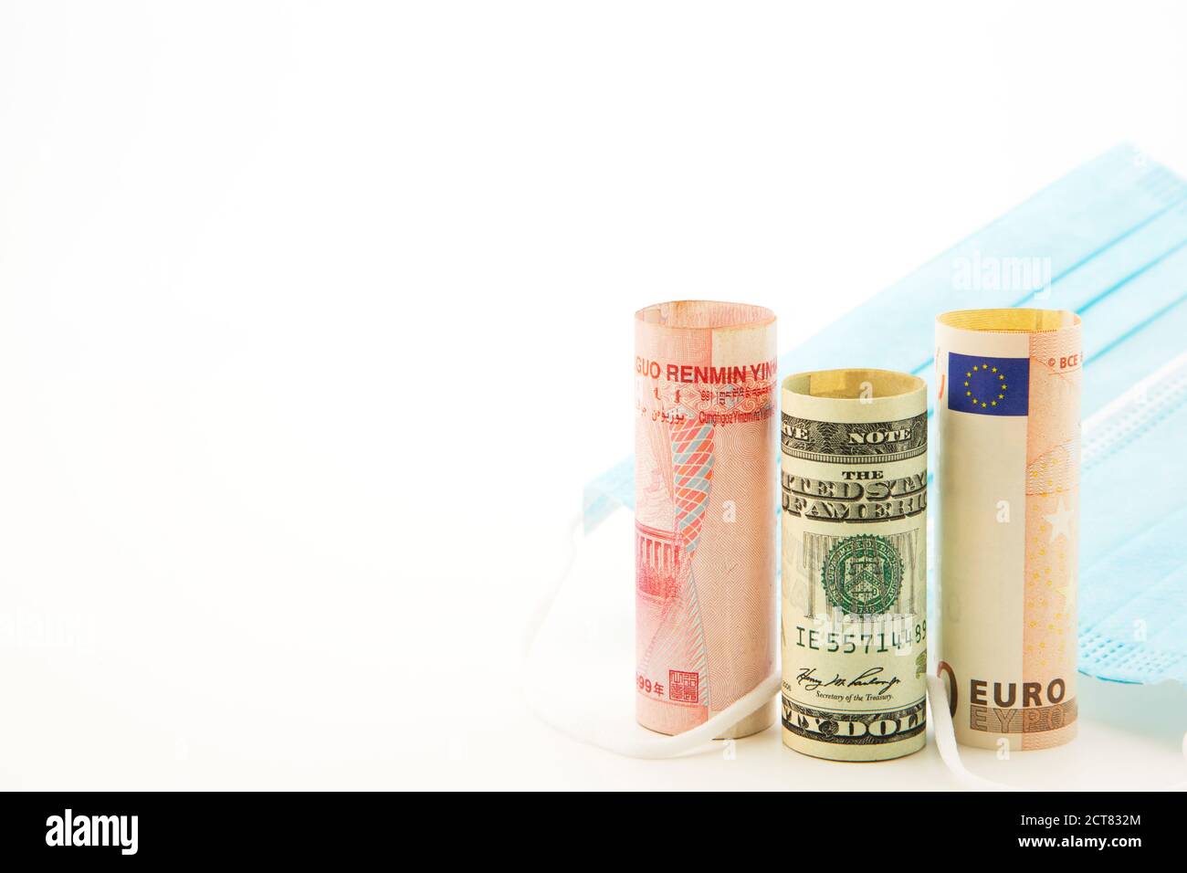 Global investments in health, medical, and pharmaceutical reflected in three currencies, yuan, dollar, and euro, next to medical protection masks Stock Photo