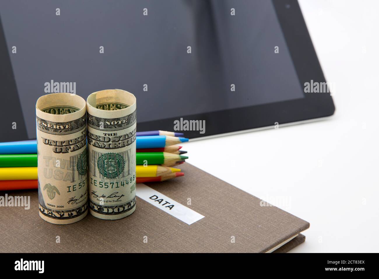 Successful investment is based on research, data, and facts seen in symbols of currency, notebook marked data, and digital tablet. Stock Photo