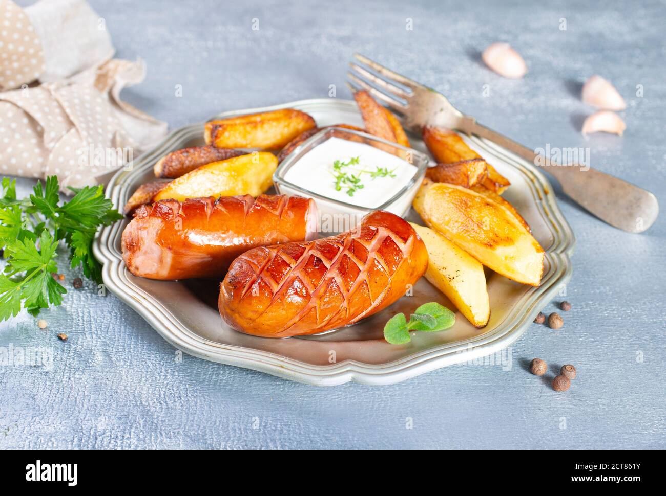 fried sausages with potato on metal plate Stock Photo