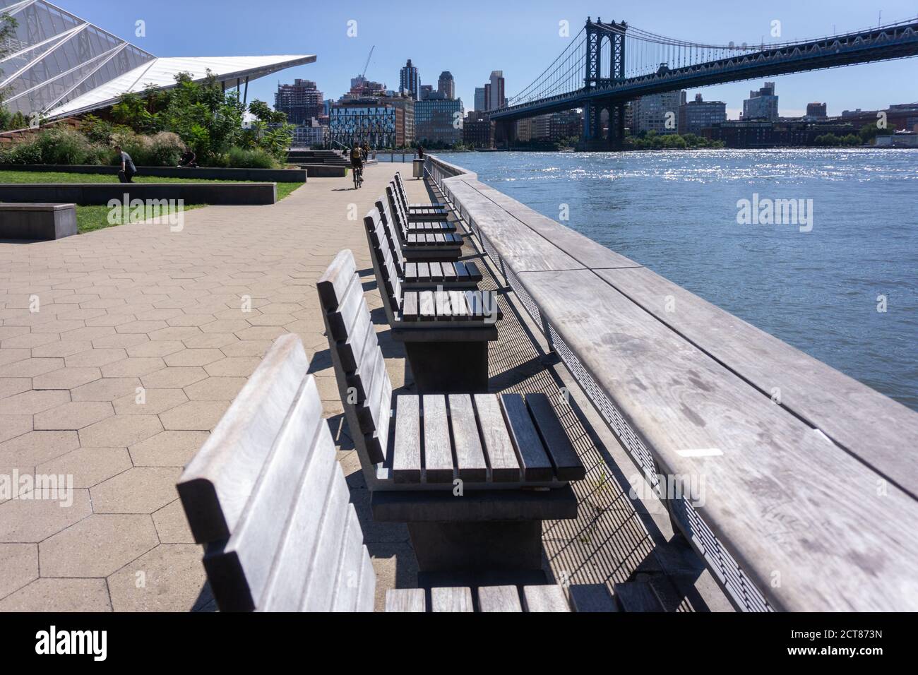Pier 35 at East River Waterfront. Empty wooden benches along pier on Lower East Side, NYC Stock Photo