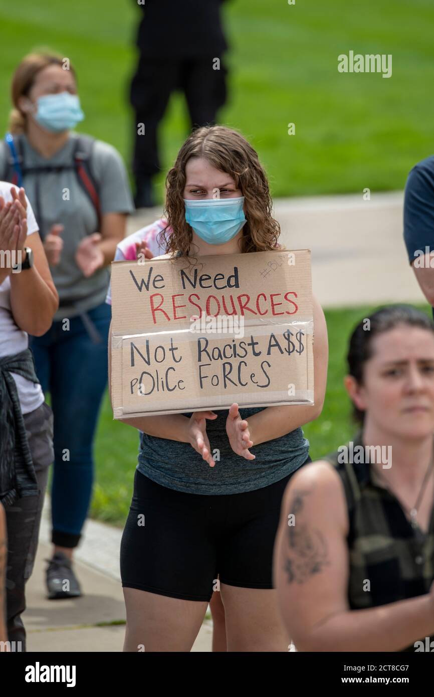 St. Paul, Minnesota. August 22, 2020. Youth march and rally to end violence. A woman protester holding we need resources not racist police forces sign Stock Photo