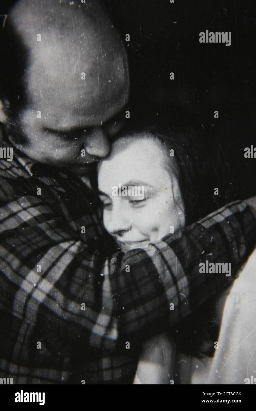 Fine 1970s black and white photography of a regular guy hugging a woman with a public display of affection, PDA. Stock Photo