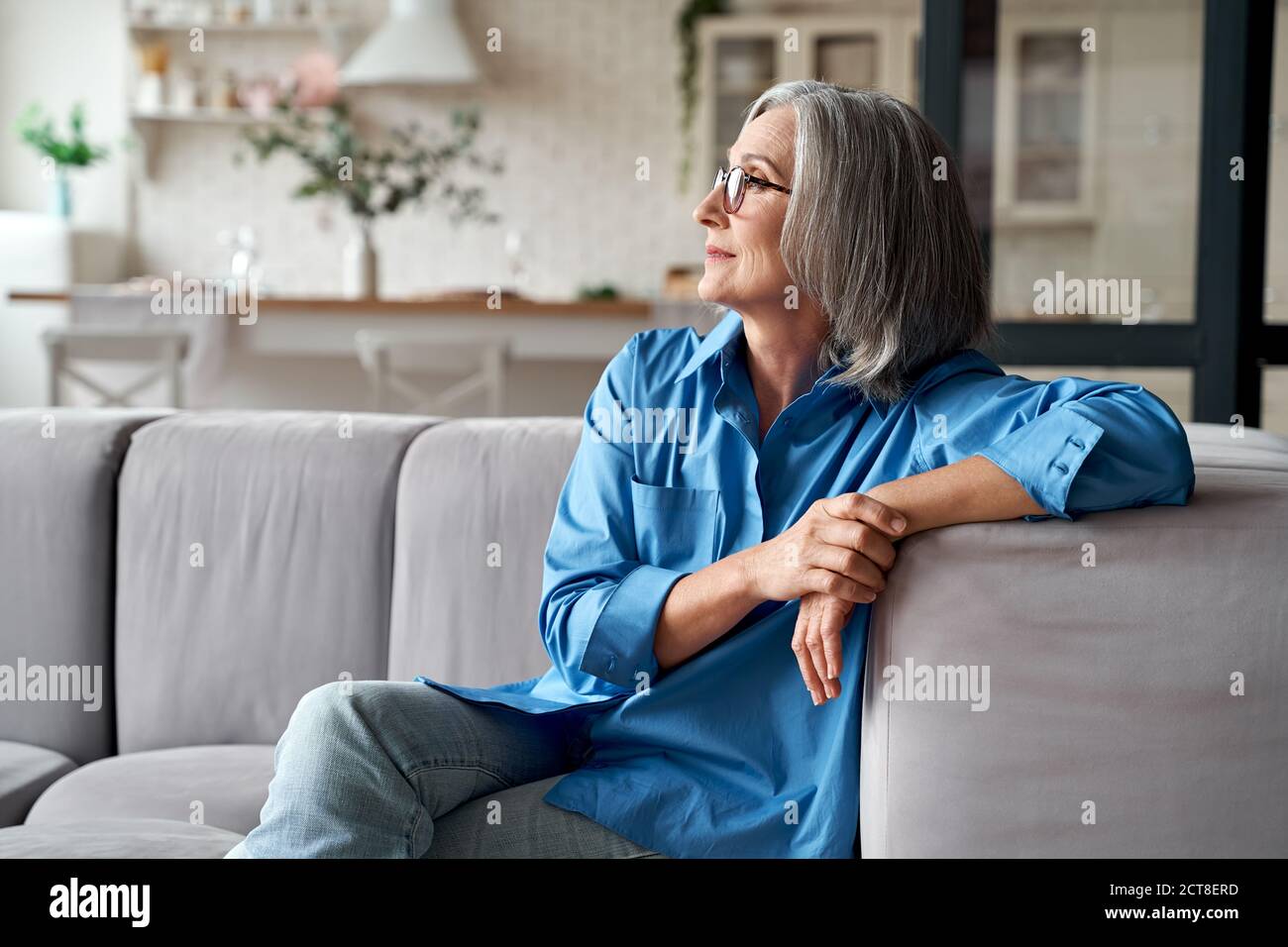 Calm relaxed mature older woman relaxing sitting on couch at home Stock ...