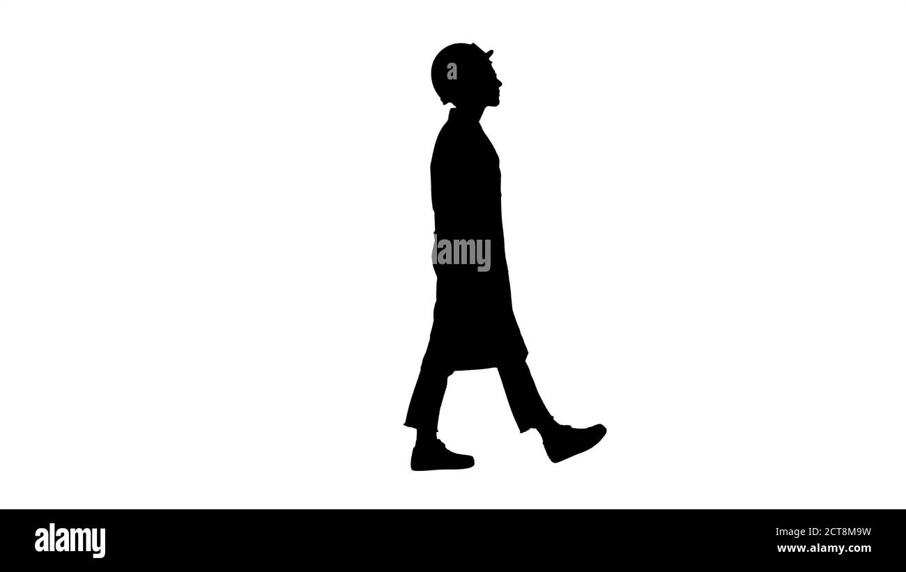 Silhouette Walking woman engineer with hands in pockets. Stock Photo