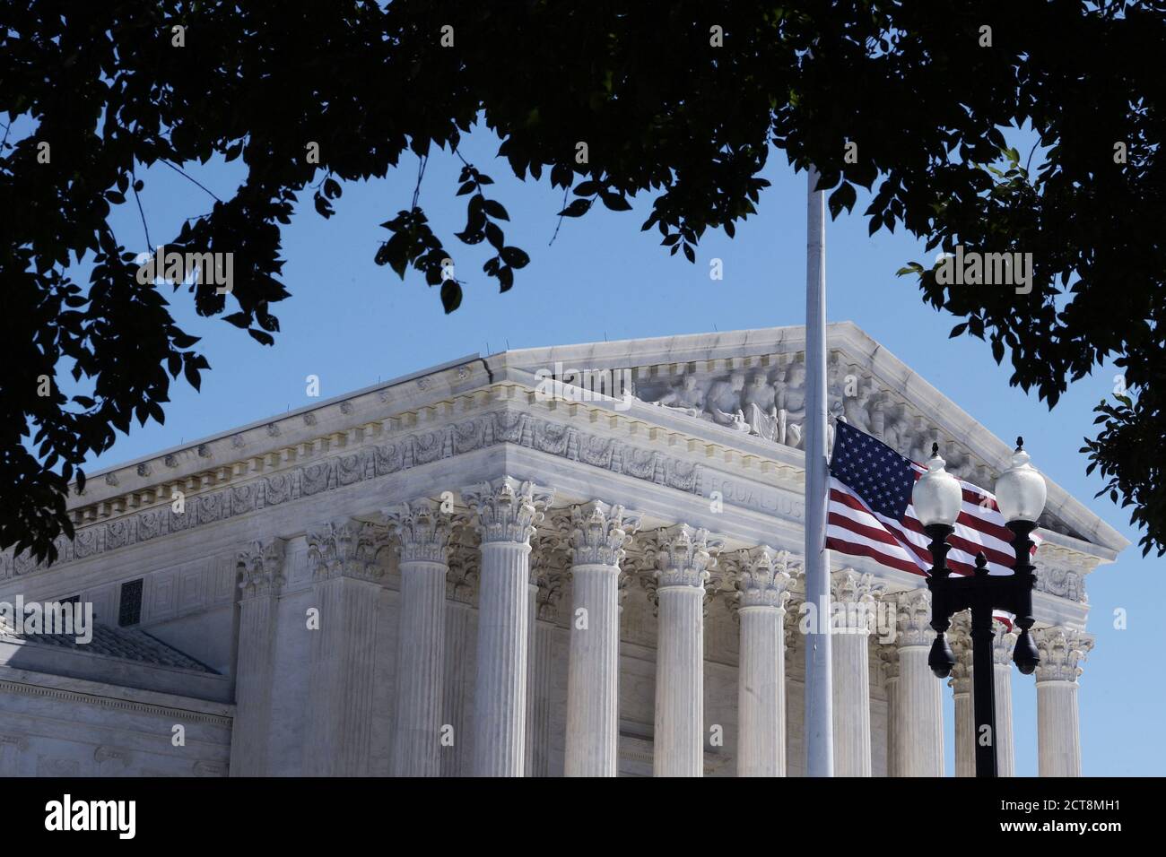 Washington, United States. 21st Sep, 2020. The US flag flies at half mast during a vigil honoring the life of the late Supreme Court Justice Ruth Bader Ginsburg.Dozens of people lay flowers and pay respects for the death of the US Supreme Court of Justice Ruth Bader Ginsburg. Credit: SOPA Images Limited/Alamy Live News Stock Photo