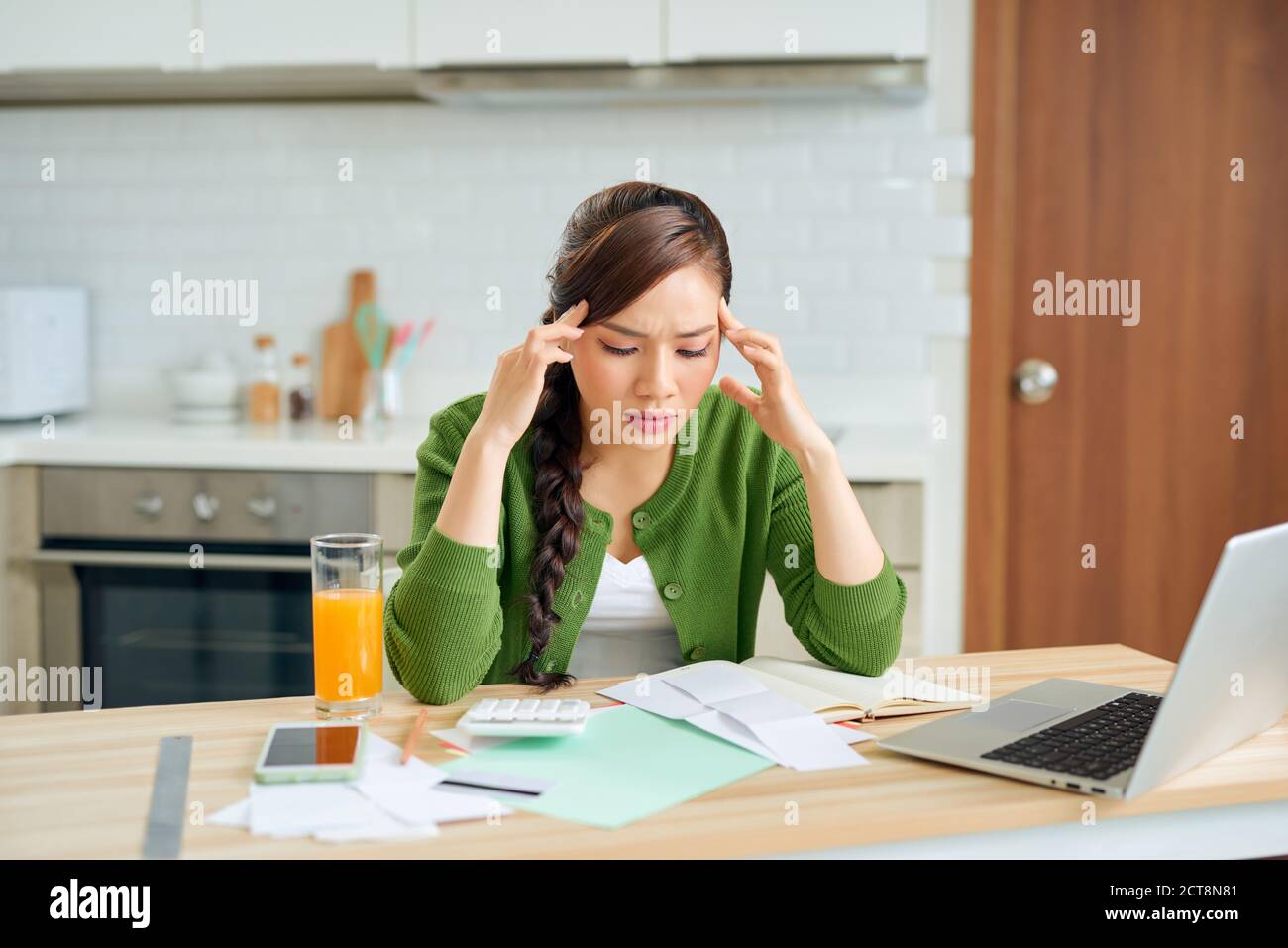 An attractive young housewife grimly considers spending this month and is under stress when checking accounts. Stock Photo