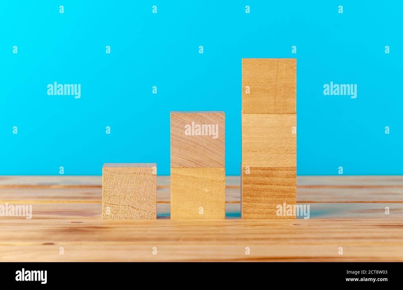 Stacked wooden blocks on wooden desk against blue background Stock ...