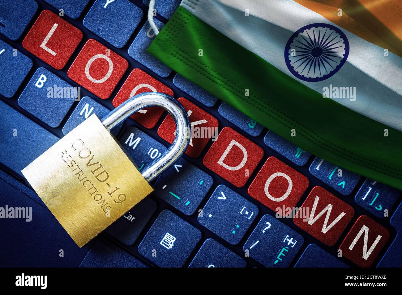 India COVID-19 coronavirus lockdown restrictions concept illustrated by padlock on laptop red alert keyboard buttons and face mask with Indian flag. Stock Photo