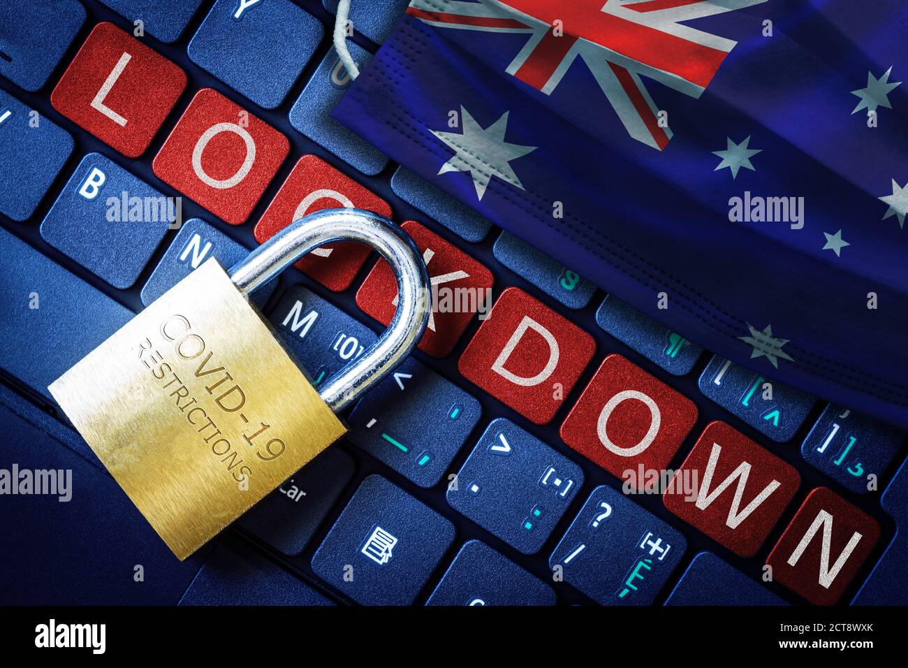 Australia COVID-19 coronavirus lockdown restrictions concept illustrated by padlock on laptop red alert keyboard buttons and face mask with Australian Stock Photo