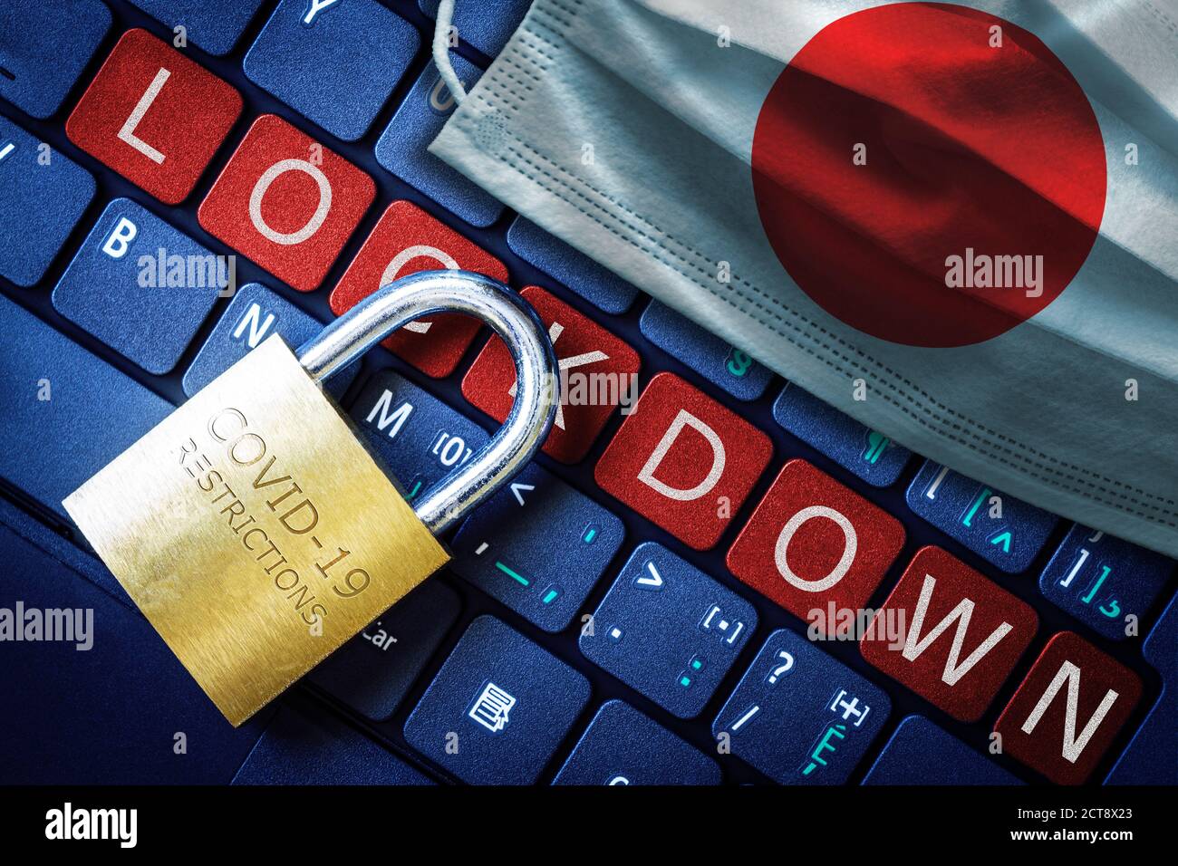 Japan COVID-19 coronavirus lockdown restrictions concept illustrated by padlock on laptop red alert keyboard buttons and face mask with Japanese flag. Stock Photo