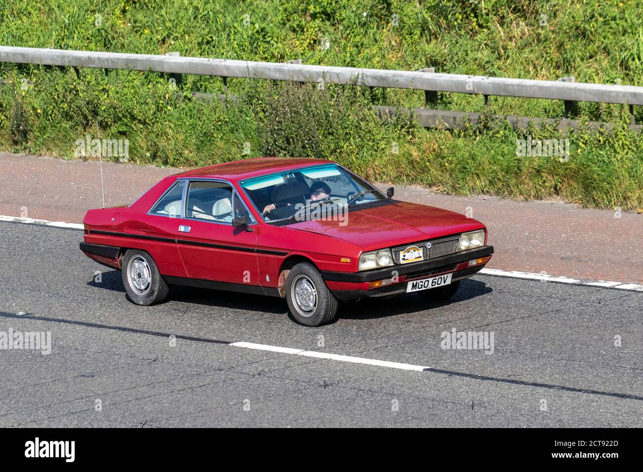 1979 70s red Lancia Gamma; Vehicular traffic moving vehicles, cars driving vehicle on UK roads, motors, motoring on the M6 motorway highway network. Stock Photo