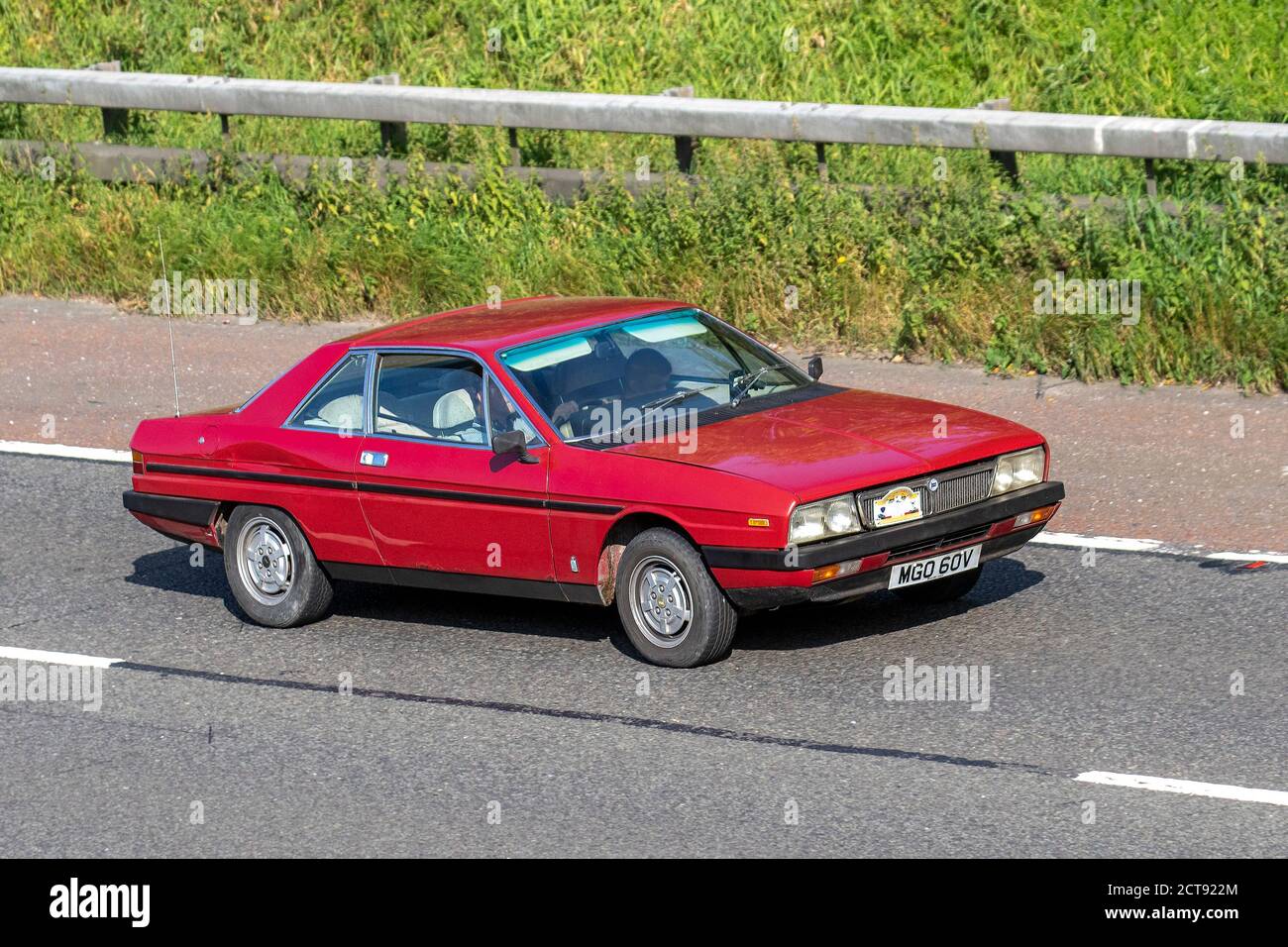 1979 red 70s Lancia Gamma; Vehicular traffic moving vehicles, cars driving vehicle on UK roads, motors, motoring on the M6 motorway highway network. Stock Photo